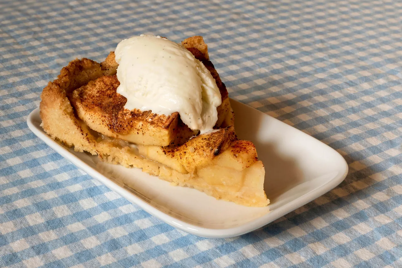 Bizcocho de manzana cortado en porciones sobre plato blanco